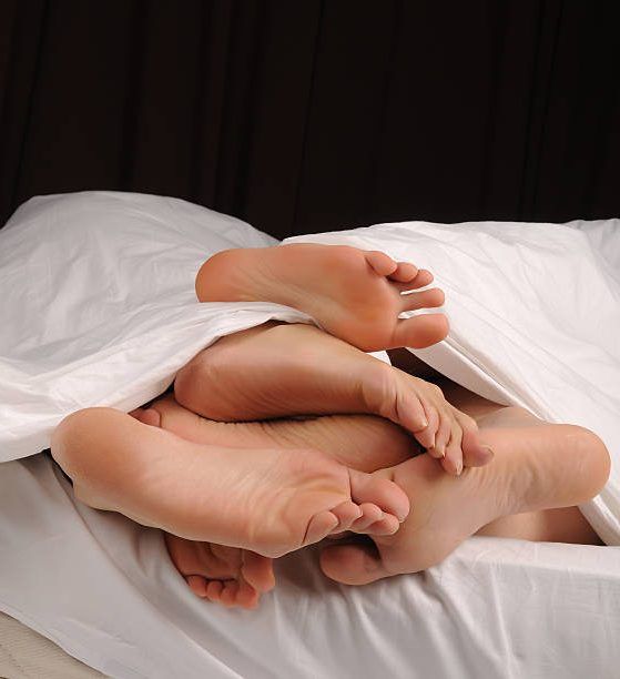 varios pies en una cama